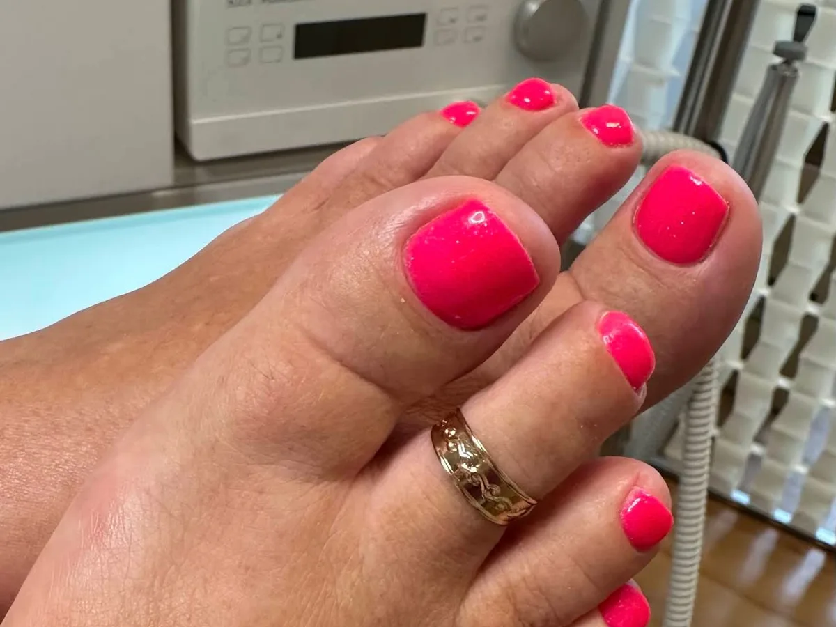 Fußpflege mit klassischem Nagellack in kräftigem Pink